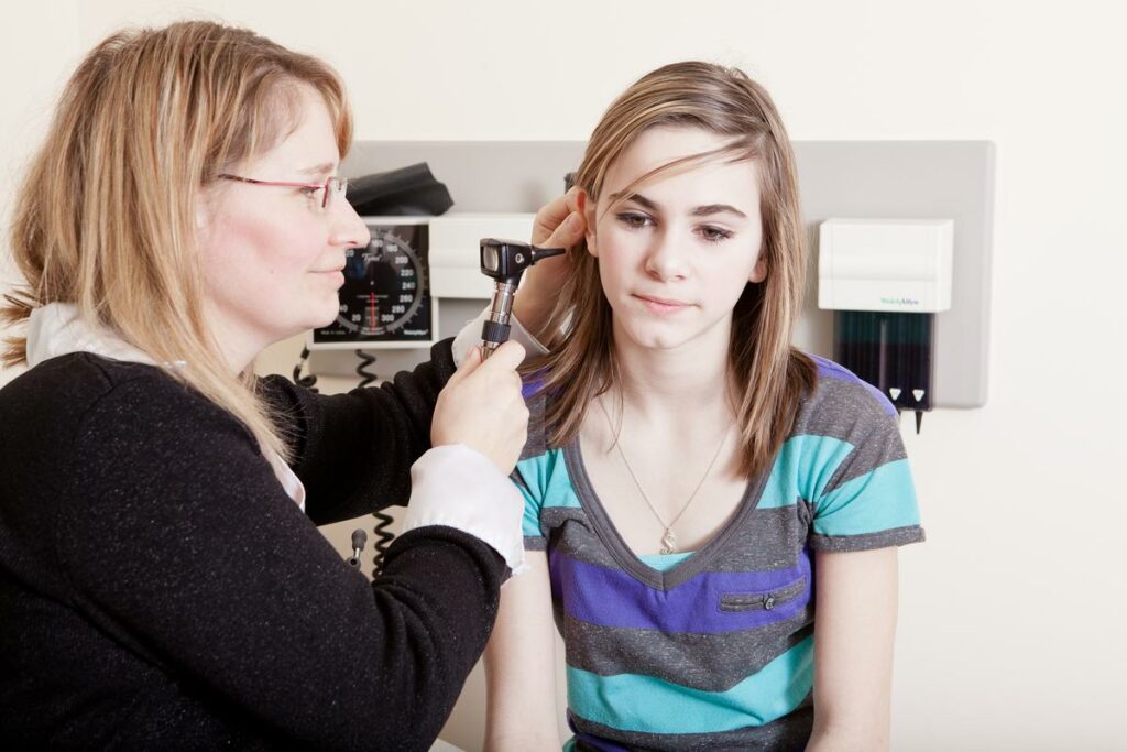 doctor looking into teens ear