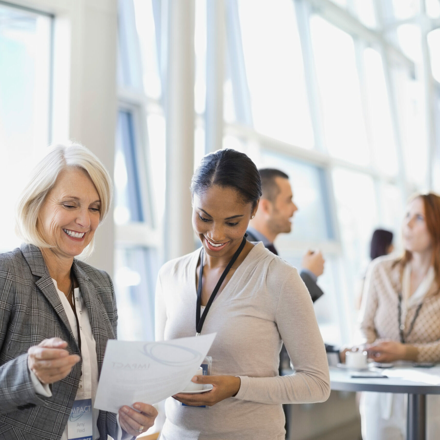 Businesswomen reviewing documents at conference